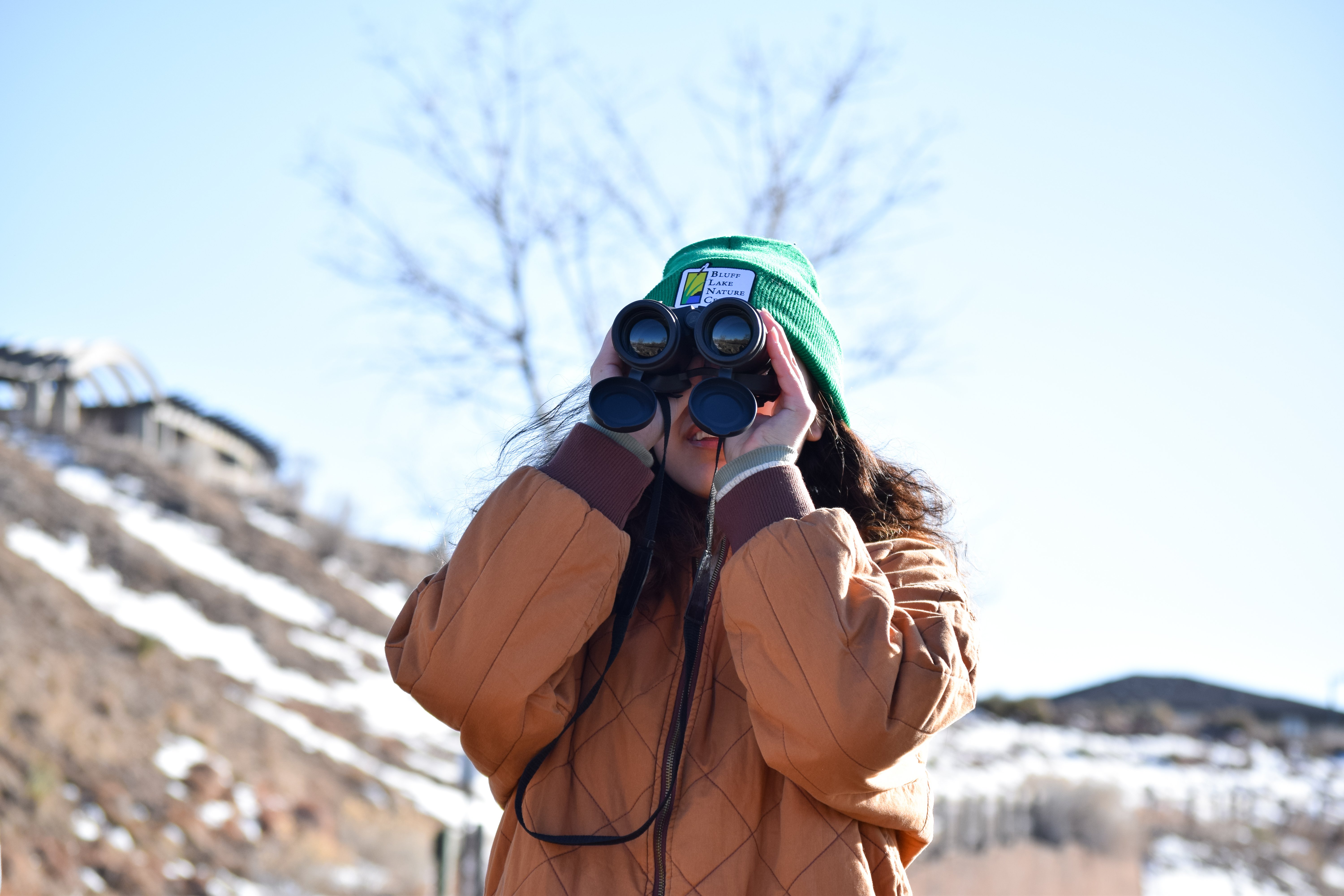 Tara uses binoculars to identify red-tailed hawks, her favorite type of bird.